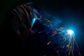 Male welder in a mask performing metal welding. photo in dark colors