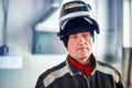 Male welder in work clothes with mask on his head looks directly into camera. Authentic portrait of worker Royalty Free Stock Photo