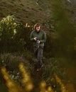 Male wildlife photographer with camera hiking in mountains