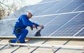 Electrician mounting solar panel on roof of modern house Royalty Free Stock Photo