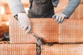 male worker, bricklayer. Professional worker building house with rubber hammer and bricks Royalty Free Stock Photo