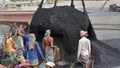 male worker is busy to loading a coal truck on his head . He is working without any safety equipment.