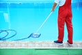 Male worker cleaning outdoor pool