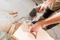 Male worker cuts the laminate Board with an electrofret saw. installing new wooden laminate flooring. concept of repair Royalty Free Stock Photo