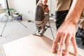 Male worker cuts the laminate Board with an electrofret saw. installing new wooden laminate flooring. concept of repair Royalty Free Stock Photo