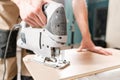 Male worker cuts the laminate Board with an electrofret saw. installing new wooden laminate flooring. concept of repair Royalty Free Stock Photo