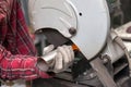 A male worker cuts a stainless steel pipe on a special machine for vertical sawing of metal parts for industrial use. Making Royalty Free Stock Photo