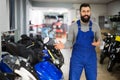 Male worker demonstrates models of motorcycles Royalty Free Stock Photo