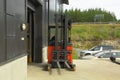 Male worker driving out of a warehouse on the fork-lift-truck