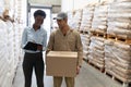 Male worker and female manager discussing on clipboard in warehouse Royalty Free Stock Photo