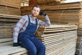 Male Worker folds boards. Sawmill. Wood harvesting process