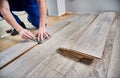 Male worker hands drawing line on laminate wood plank. Royalty Free Stock Photo