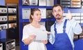 Male worker helping young consumer woman looking new mailbox Royalty Free Stock Photo