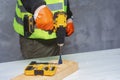 Male worker holds a close-up electric cordless screwdriver in his hands against the background of a construction tool and a Royalty Free Stock Photo