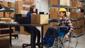 Male worker with impairment taking boxes off of shelves Royalty Free Stock Photo