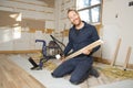 A Male Worker install wood floor on a house