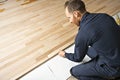 A Male Worker install wood floor on a house