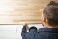 A Male Worker install wood floor on a house