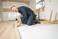 A Male Worker install wood floor on a house