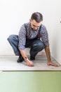 Male worker installing laminate flooring, man installing new wooden laminate flooring. Man laying laminate flooring at home. Carpe Royalty Free Stock Photo