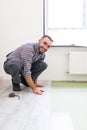 Male worker installing laminate flooring, man installing new wooden laminate flooring. Man laying laminate flooring at home. Carpe Royalty Free Stock Photo