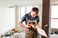 Male worker cuts the laminate Board with sandpaper. installing new wooden laminate flooring. concept of repair in house. Royalty Free Stock Photo