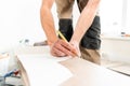 Male worker applies markings to the Board for cutting with a electrofret saw. installing new wooden laminate flooring Royalty Free Stock Photo