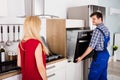 Male Worker Installing Oven For Repairing In Kitchen Royalty Free Stock Photo