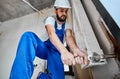 Male worker installing radiator in apartment.