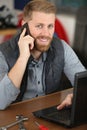 Male worker with laptop phoning customer Royalty Free Stock Photo