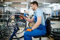 Male worker at the machine tool checks bicycle rim Royalty Free Stock Photo