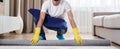 Close up of man unrolling carpet. Cleaning service concept Royalty Free Stock Photo