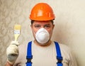 A male worker paints a surface with a brush