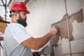 Male worker plastering old building wall using cement plaster mix Royalty Free Stock Photo