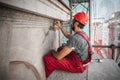 Male worker plastering old building wall using cement plaster mix Royalty Free Stock Photo