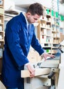 male worker processing plank in machine at workshop