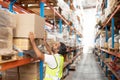 Male worker putting cardboard box on a rack in warehouse Royalty Free Stock Photo