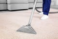 Male worker removing dirt from carpet