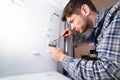 Male Worker Repairing Refrigerator In Kitchen Room Royalty Free Stock Photo