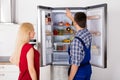 Male Worker Repairing Refrigerator In Kitchen Room Royalty Free Stock Photo