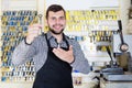 Male worker showing key he made in repair workshop Royalty Free Stock Photo