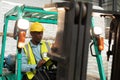 Male worker sitting in forklift and writing on clipboard in warehouse Royalty Free Stock Photo