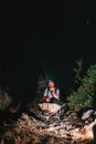 A male worker is sitting in a wheelbarrow. Night view. Headlamp illuminates the trail. The concept of heavy utility and