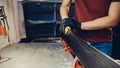 Male worker of ski service workshop doing sharpening and repair of skis. Sharpening ski edges with a manual side-edge tuning tool Royalty Free Stock Photo