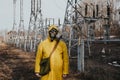 male worker standing on territory of power station. Environmentalist wearing protective uniform, gas mask.