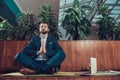 Male worker meditating on bench in office. Royalty Free Stock Photo