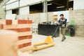 Male worker is about to load a pallet jack with wood Royalty Free Stock Photo