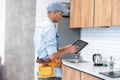 Male worker types on a tablet, kitchen renovation Royalty Free Stock Photo
