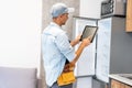 Male worker types on a tablet, kitchen renovation Royalty Free Stock Photo