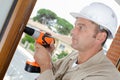 male worker using cordless drill on window Royalty Free Stock Photo